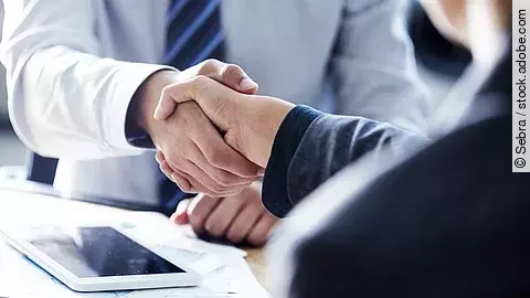 Händeschütteln Händeschütteln zweier sich gegenübersitzenden Personen