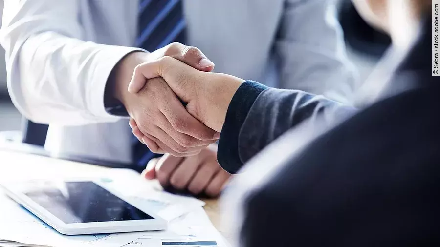 Händeschütteln Händeschütteln zweier sich gegenübersitzenden Personen