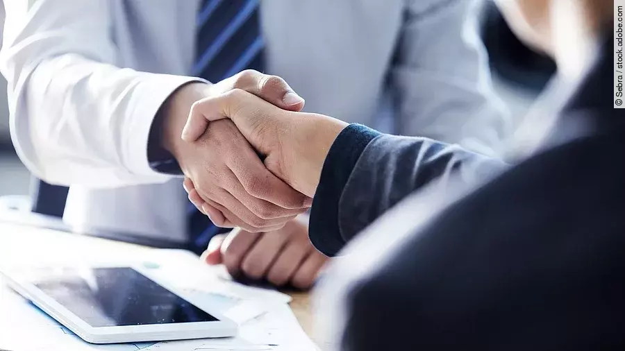 Händeschütteln Händeschütteln zweier sich gegenübersitzenden Personen