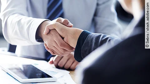 Händeschütteln Händeschütteln zweier sich gegenübersitzenden Personen