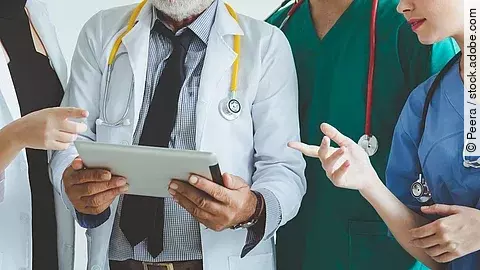Ärzte mit Tablet in der Hand besprechen sich.
