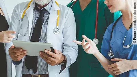 Ärzte mit Tablet in der Hand besprechen sich.