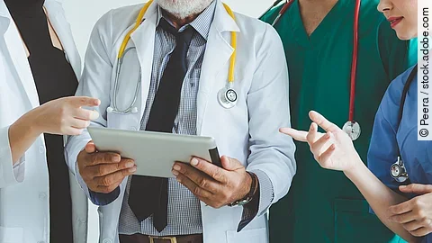 Ärzte mit Tablet in der Hand besprechen sich.