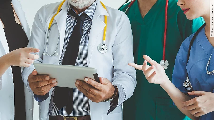 Ärzte mit Tablet in der Hand besprechen sich.