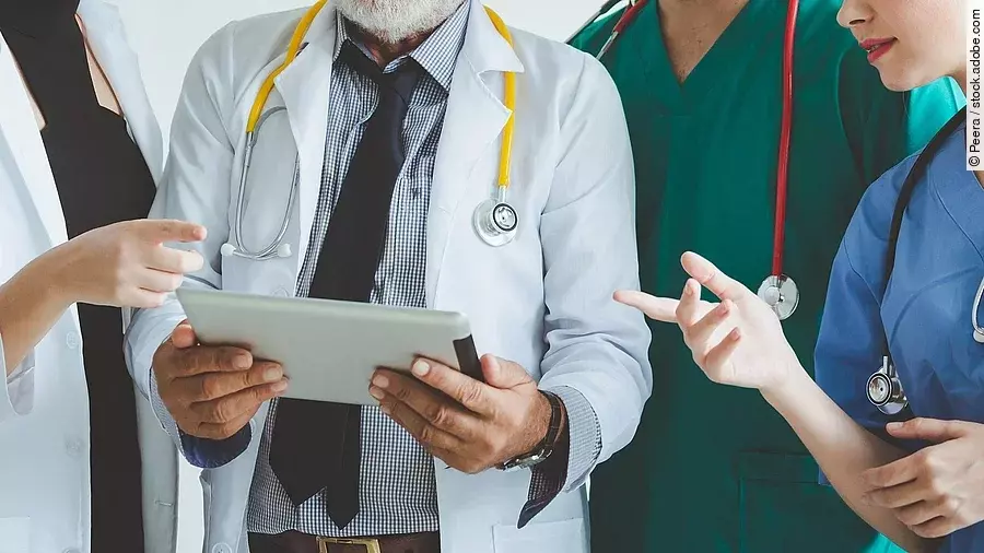 Ärzte mit Tablet in der Hand besprechen sich.
