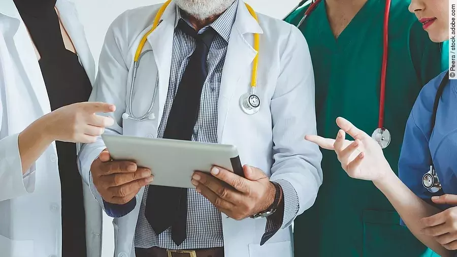 Ärzte mit Tablet in der Hand besprechen sich.