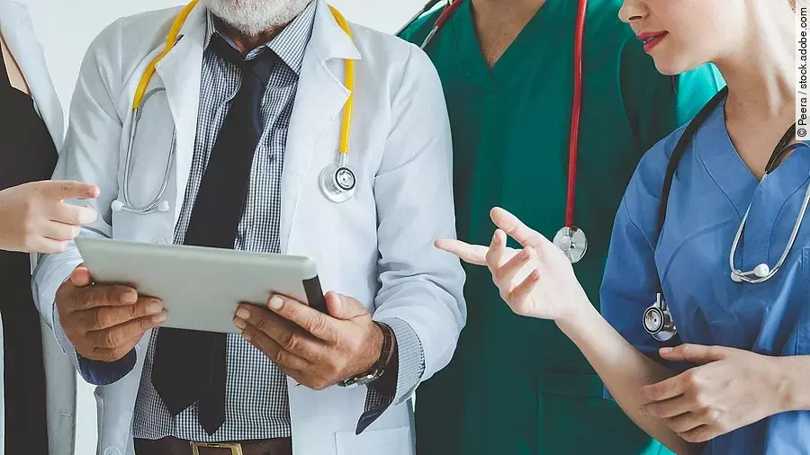 Ärzte mit Tablet in der Hand besprechen sich.