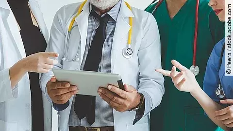 Ärzte mit Tablet in der Hand besprechen sich.