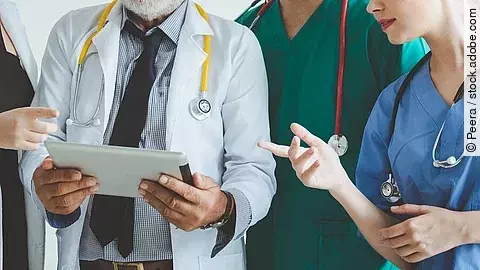 Ärzte mit Tablet in der Hand besprechen sich.