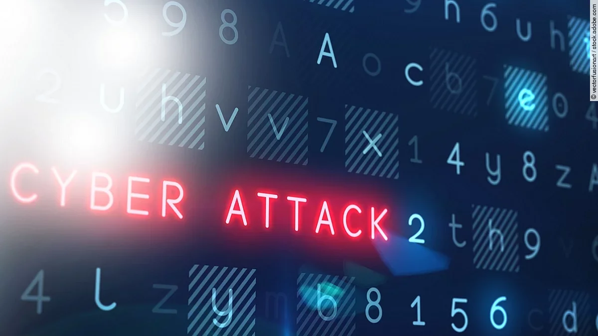 Cyberattacke In einem Raster aus blauen Ziffern und Buchstaben leuchtet der Begriff "Cyber Attack" rot auf.