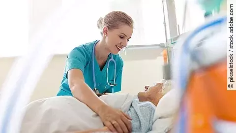 Pflegefachkraft versorgt Seniorin im Krankenhaus