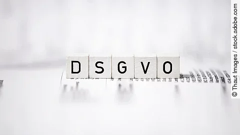 Weiße Holzwürfel mit Buchstaben-Aufdruck bilden die Abkürzung "DSGVO"