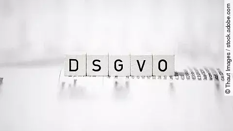 Weiße Holzwürfel mit Buchstaben-Aufdruck bilden die Abkürzung "DSGVO"