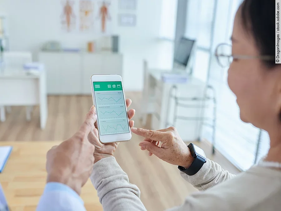 Gesundheitsapp Zwei Personen begutachten die Auswertung einer Gesundheitsapp auf dem Smartphone.
