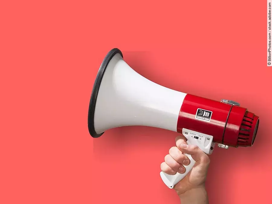 Achtung Megaphon wird vor roten Hintergrund gehalten.