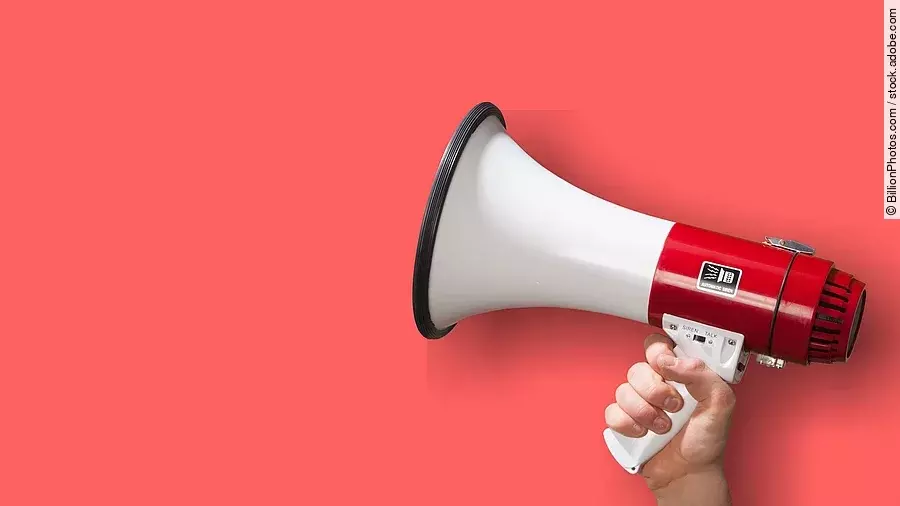 Achtung Megaphon wird vor roten Hintergrund gehalten.