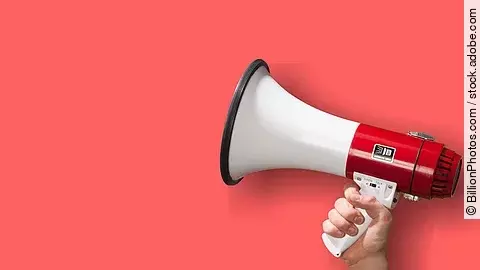 Megaphon wird vor roten Hintergrund gehalten.