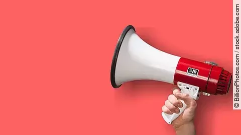 Megaphon wird vor roten Hintergrund gehalten.