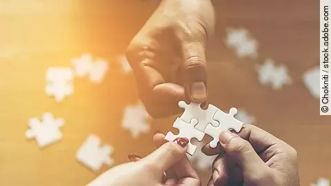 Zusammenschluss Drei Hände setzen drei Puzzlestücke zusammen