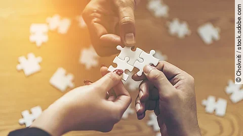 Zusammenschluss Drei Hände setzen drei Puzzlestücke zusammen