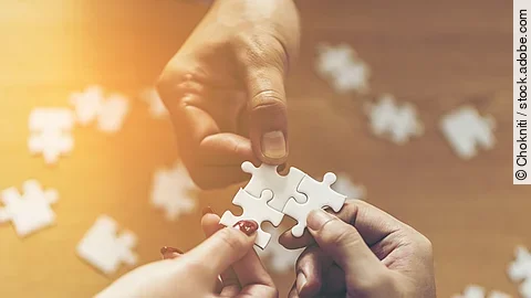 Zusammenschluss Drei Hände setzen drei Puzzlestücke zusammen