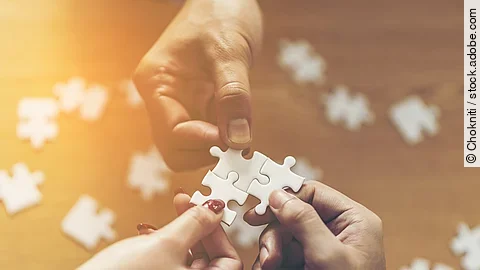 Zusammenschluss Drei Hände setzen drei Puzzlestücke zusammen