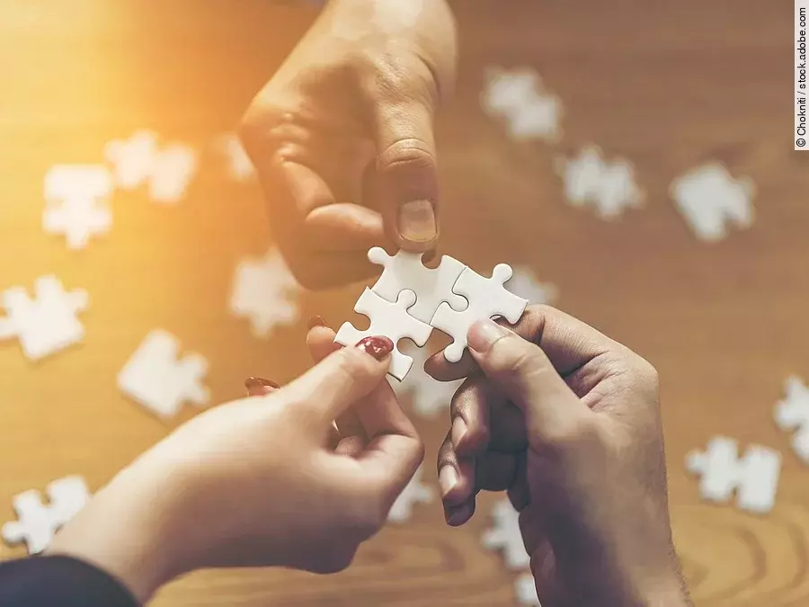 Zusammenschluss Drei Hände setzen drei Puzzlestücke zusammen