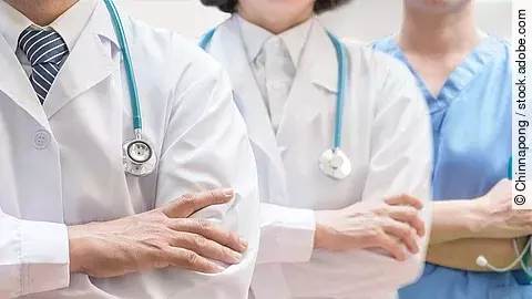 Klinikpersonal Drei Personen stehen nebeneinander. Links ein Arzt in weißem Kittel, in der Mitte eine Ärztin mit weißem Kittel, rechts eine Krankenschwester in blauem Kasack. Es sind jeweils nur die Torsi zu sehen. Alle drei haben ein Stethoskop.