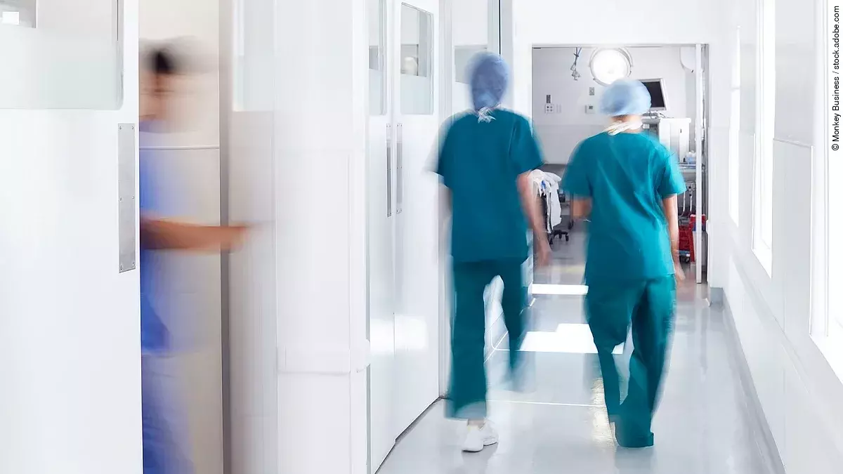 Ärzte und Pfleger gehen über einen Krankenhausflur