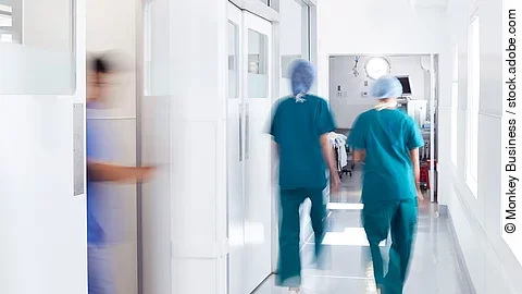 Ärzte und Pfleger gehen über einen Krankenhausflur