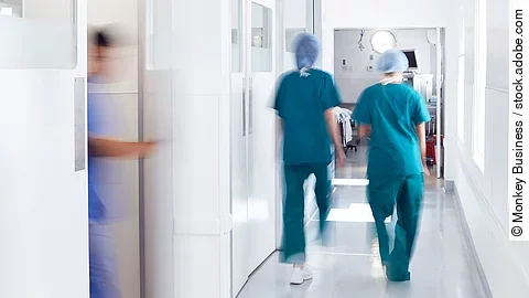 Ärzte und Pfleger gehen über einen Krankenhausflur