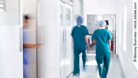 Ärzte und Pfleger gehen über einen Krankenhausflur
