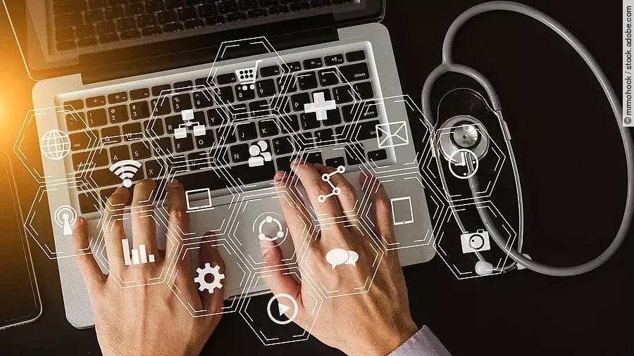 Über einer Laptop Tastatur schwebt ein holografisches Netz.