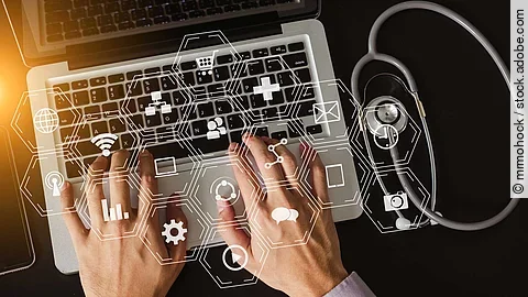 Über einer Laptop Tastatur schwebt ein holografisches Netz.