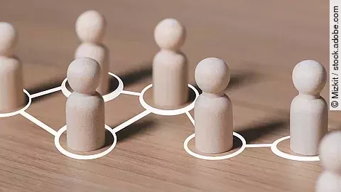 Weiße mit Linien verbundene Kreise, in denen hölzerne Spielfiguren stehen