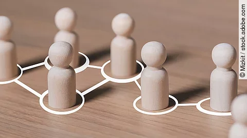 Weiße mit Linien verbundene Kreise, in denen hölzerne Spielfiguren stehen