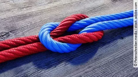 Kreuzknoten Ein rotes und ein blaues Seil bilden einen Kreuzknoten.