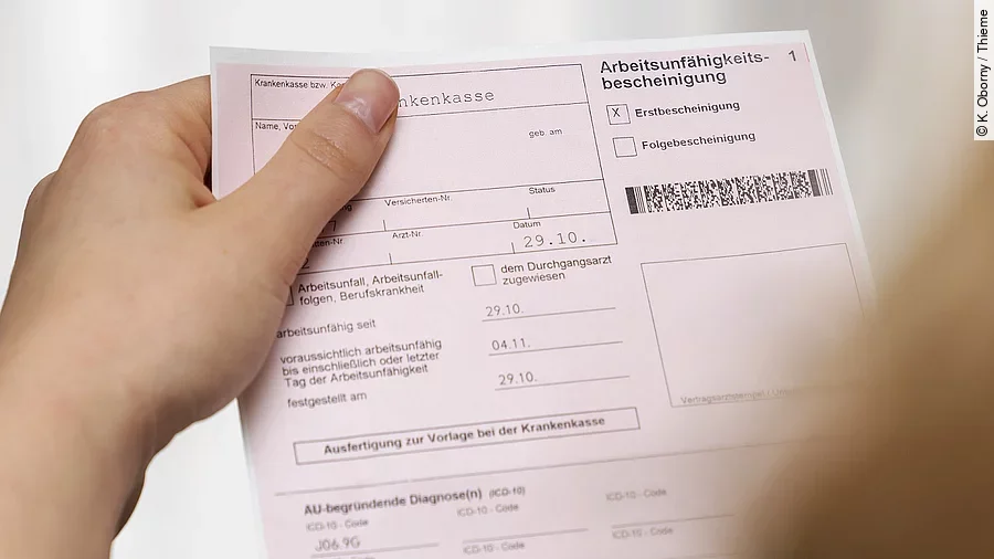 Arbeitsunfähigkeitsbescheinigung Eine Person hält eine Arbeitsunfähigkeitsbescheinigung in der Hand.
