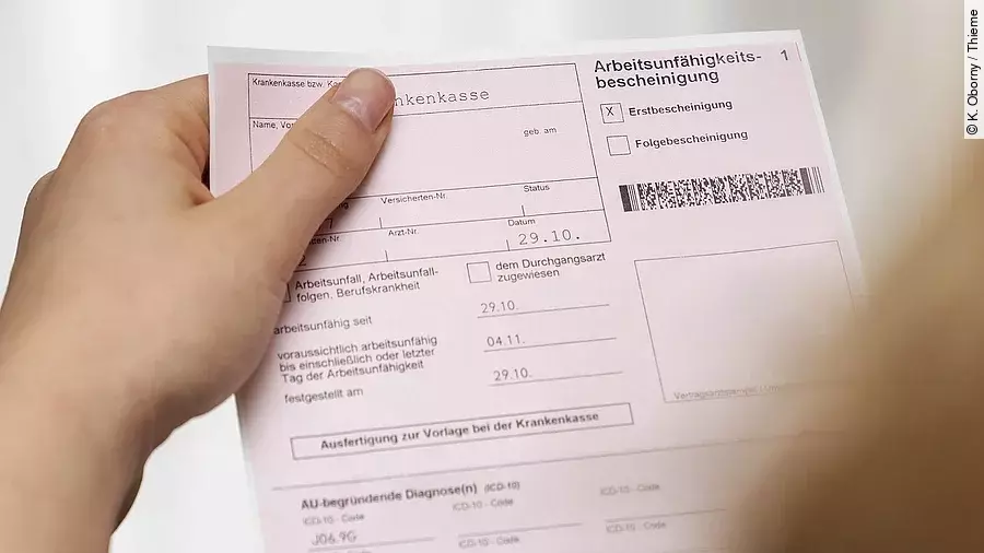 Arbeitsunfähigkeitsbescheinigung Eine Person hält eine Arbeitsunfähigkeitsbescheinigung in der Hand.