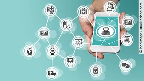 Aus einem Smartphone kommt ein graphisches Netzwerk, das verschiedene Bereiche des Gesundheitswesens zeit: Medikamente, Krankenwagen, Pflege, Dokumente, Arztkoffer und weitere.