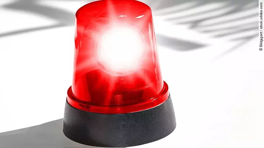 Alarm Eine rote Sirene vor weißem Hintergrund.