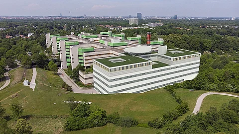 Ein Gebäude, von oben, umgeben von einer Wiese.
