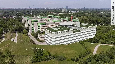 Ein Gebäude, von oben, umgeben von einer Wiese.