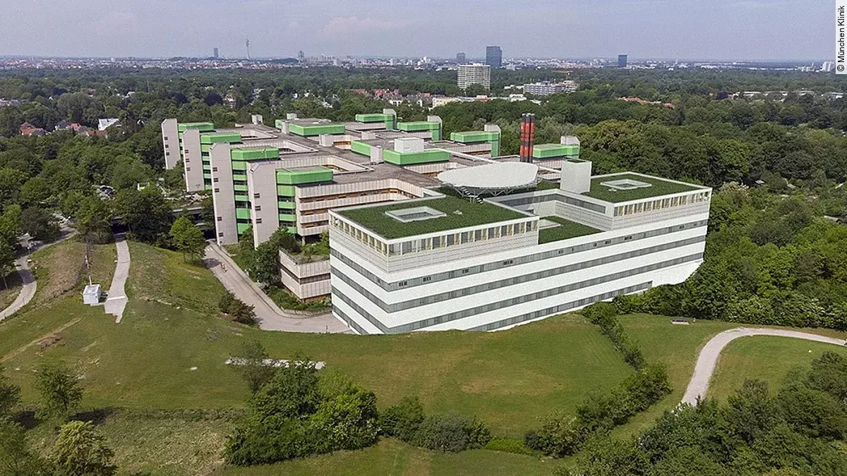 Ein Gebäude, von oben, umgeben von einer Wiese.