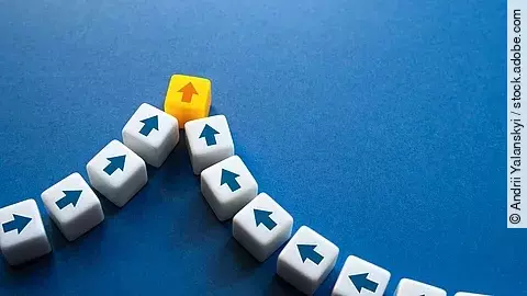 Bausteine mit Pfeilen darauf kommen aus unterschiedlichen Richtungen und werden zusammengeführt.