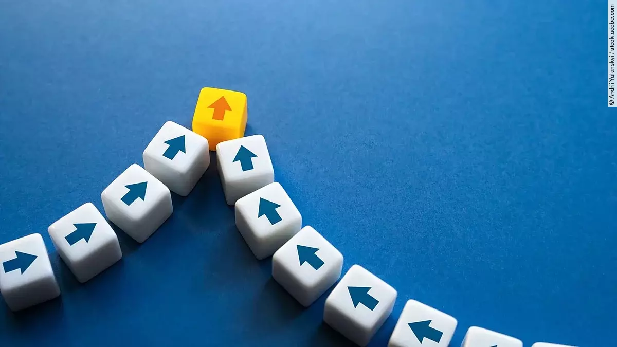 Bausteine mit Pfeilen darauf kommen aus unterschiedlichen Richtungen und werden zusammengeführt.