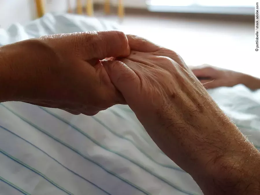 Zwei Hände, die sich auf einem weißen Bettlaken halten