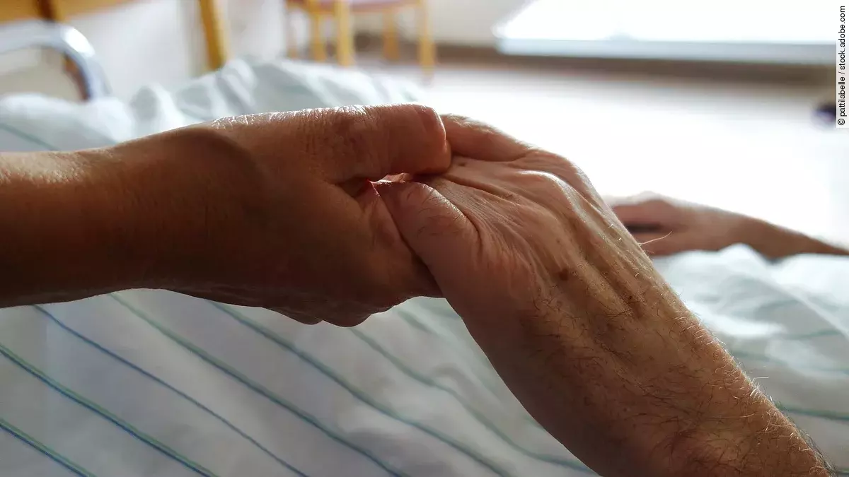 Zwei Hände, die sich auf einem weißen Bettlaken halten
