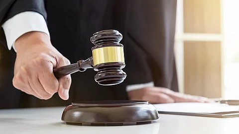 Urteil Die männliche Hand eines Richters oder Anwalts schlägt mit dem Richterhammer auf den Holzblock