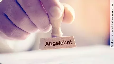Eine Hand hält einen Stempel mit dem Aufdruck Abgelehnt